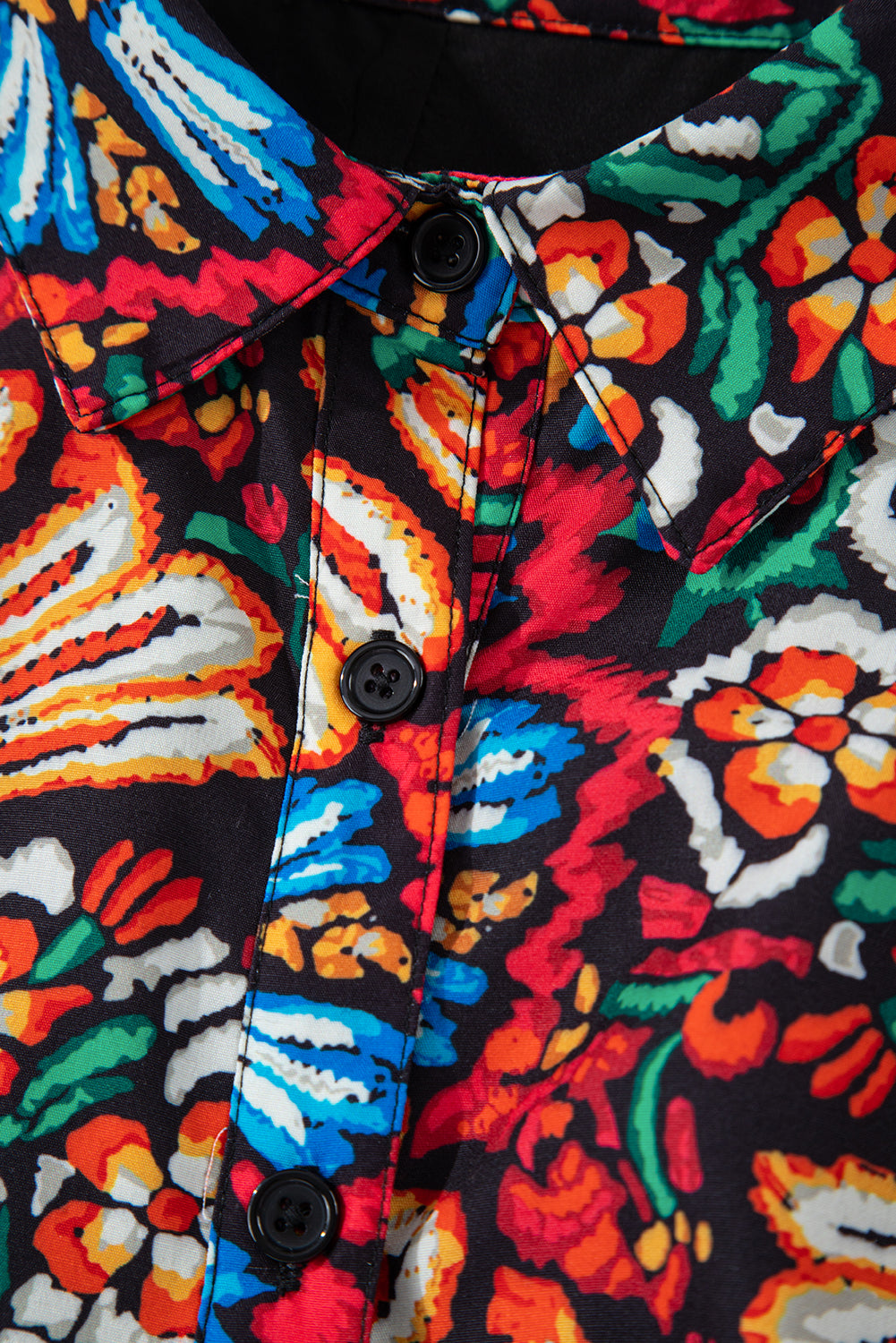 Close-up of colorful floral button-up shirt collar with vibrant red, blue, green, and orange print