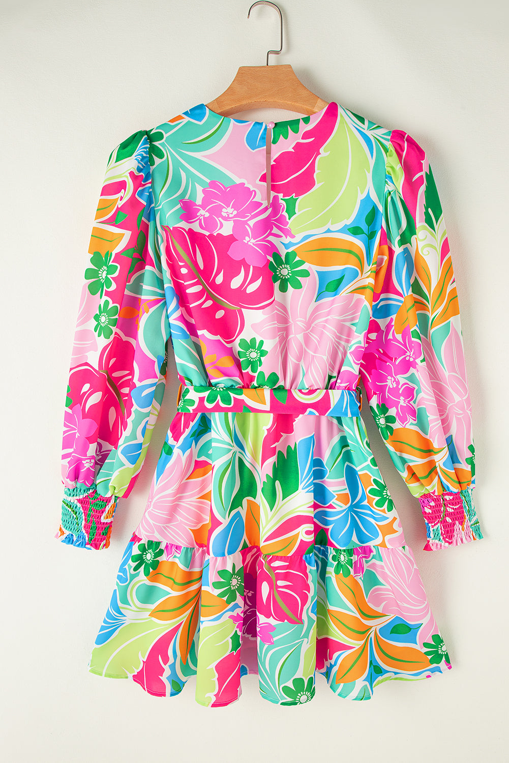 Colorful floral print mini dress with long sleeves and gathered cuffs, hanging on a hanger