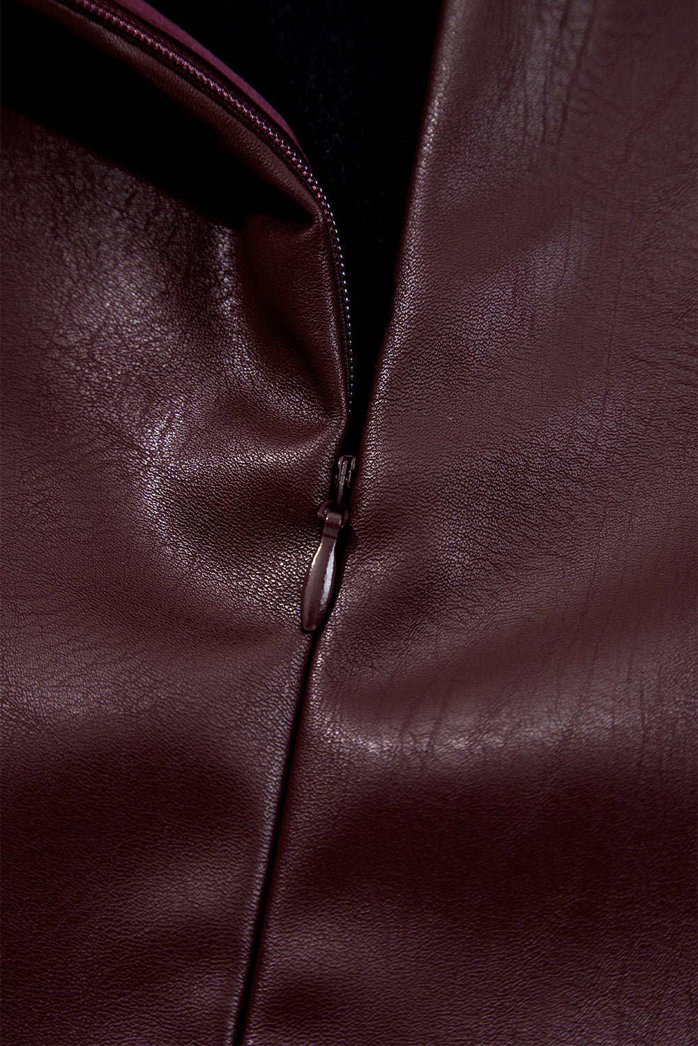Close-up of brown faux leather garment with zipper detail