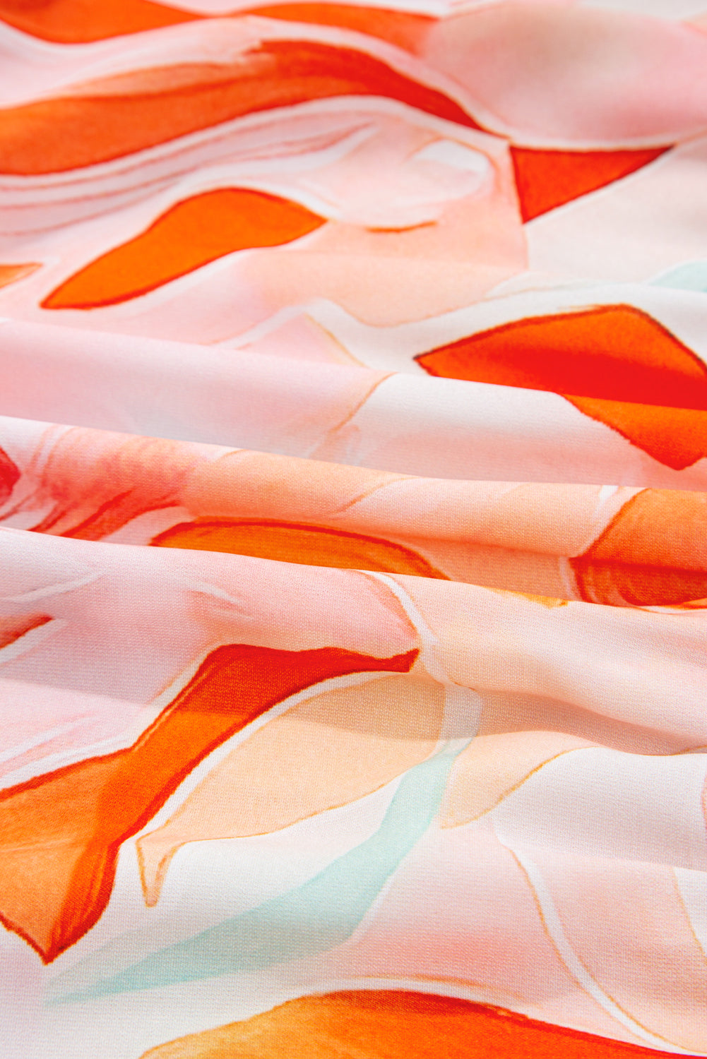 Close-up of soft fabric with orange and pink abstract floral print