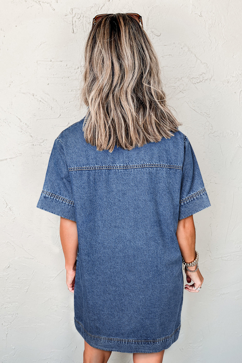 Woman wearing short sleeve denim dress, viewed from the back, casual style