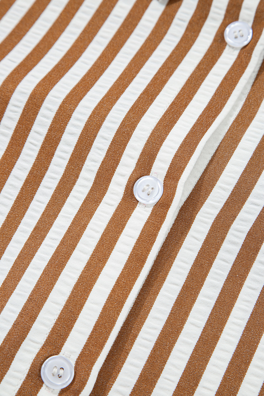 Close-up of brown and white vertical striped shirt with white buttons