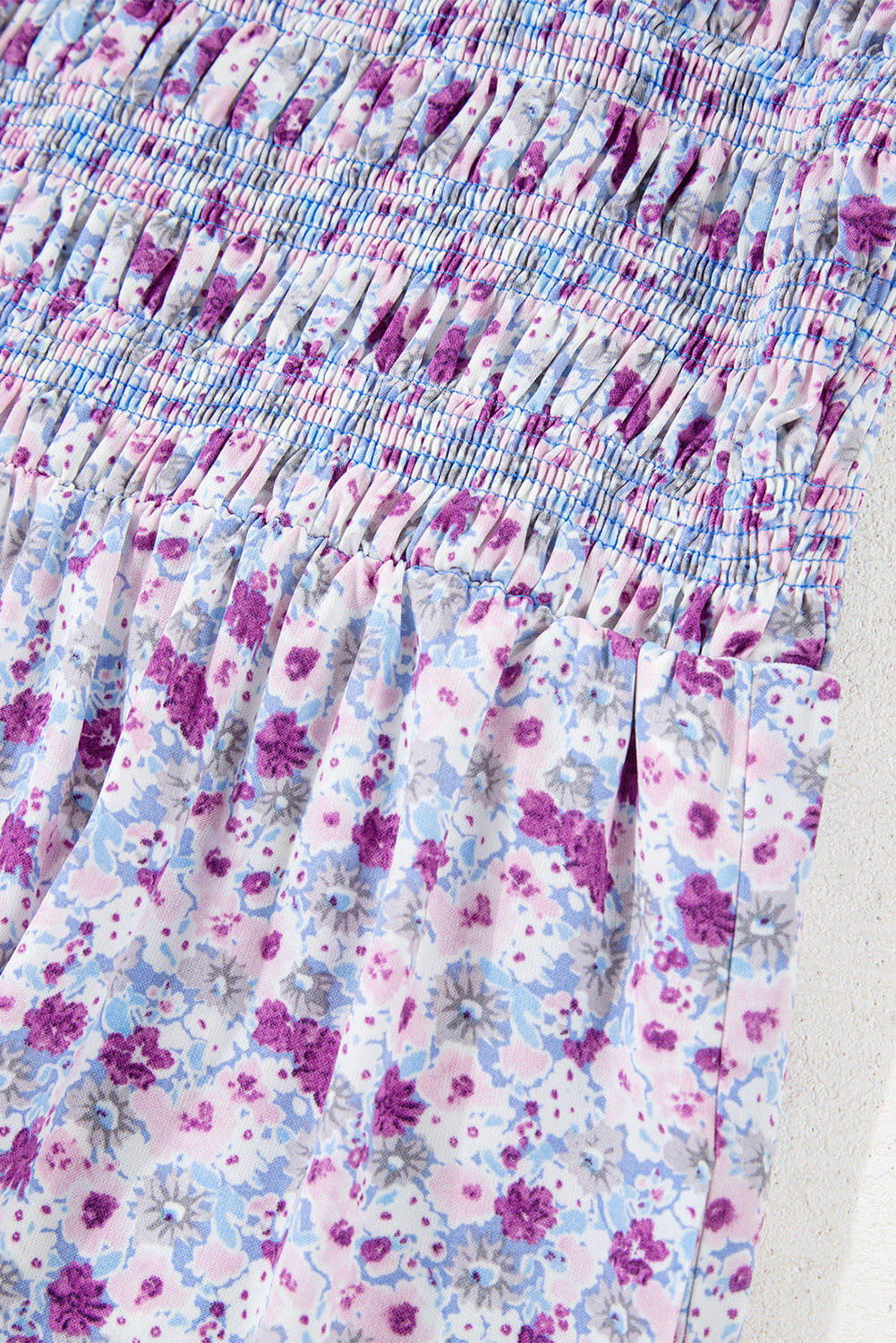 Close-up of ruched floral fabric with pink, purple, and blue flower pattern