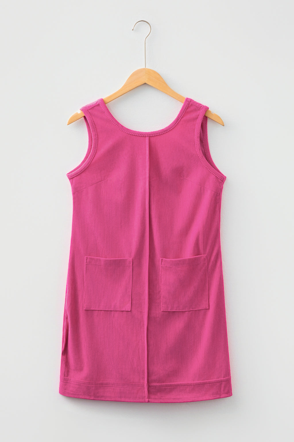Pink sleeveless corduroy dress with front pockets on hanger
