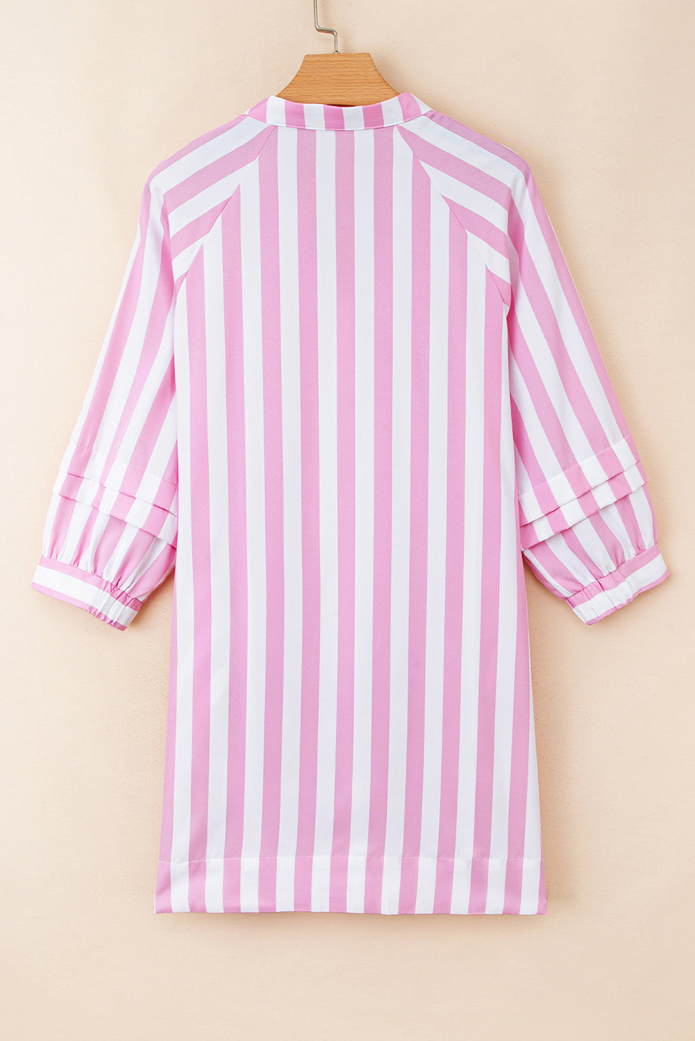 Back view of a pink and white vertical striped long-sleeve dress on a hanger