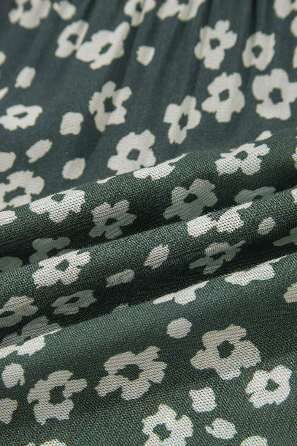 Close-up of green fabric with white floral print pattern, soft textured material
