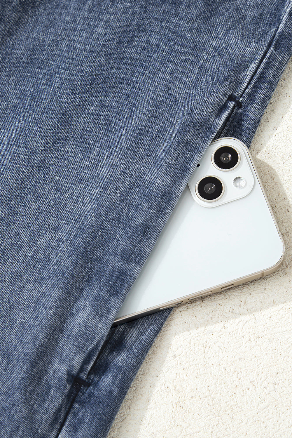 Blue denim jeans pocket with a white smartphone partially visible
