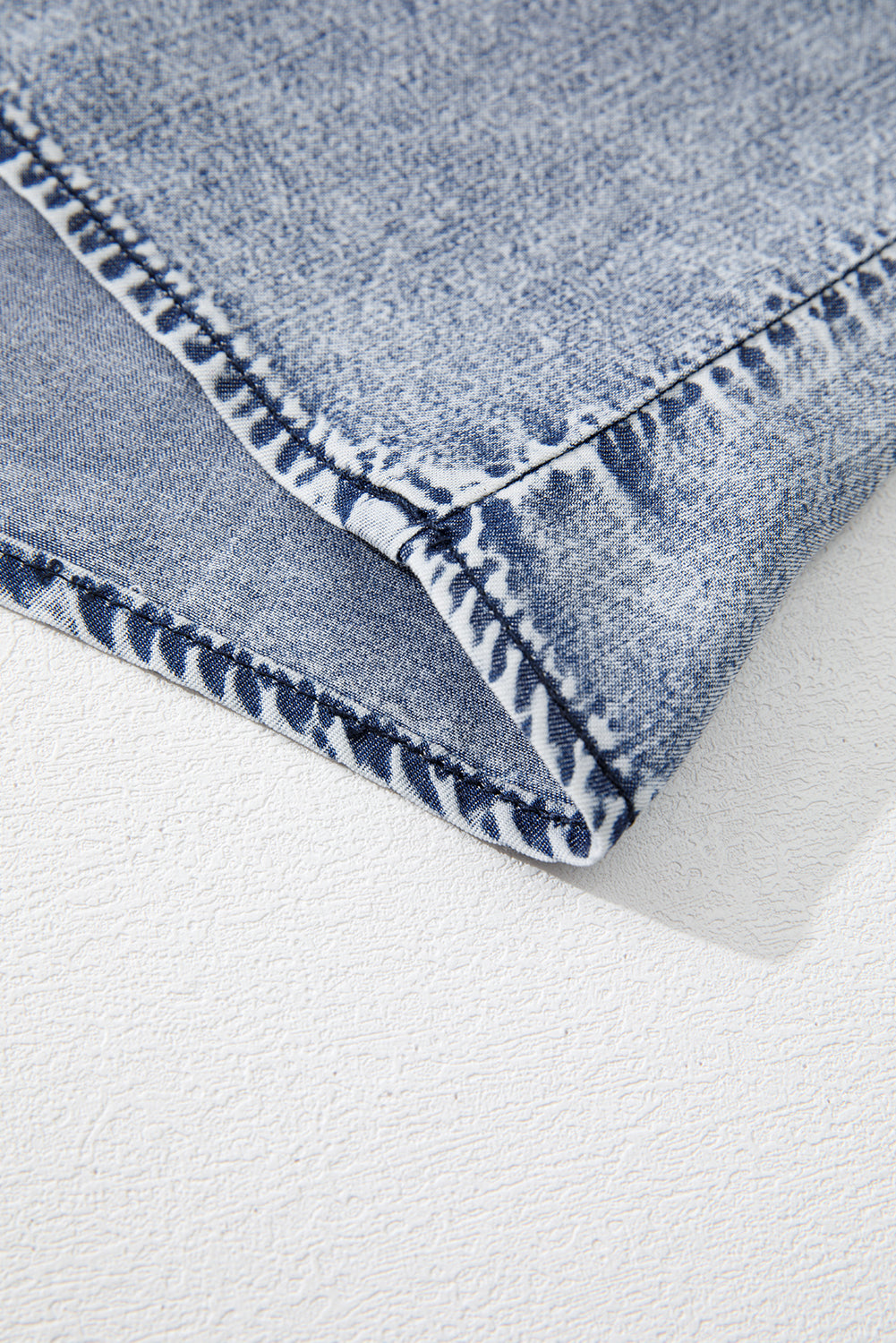 детайл на шев и подгъв на син деним топ