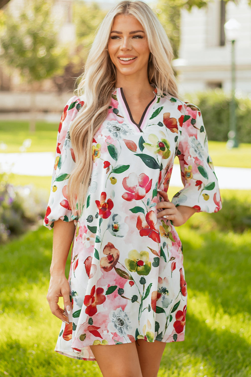 Woman wearing a floral print dress with V-neck and puff sleeves outdoors