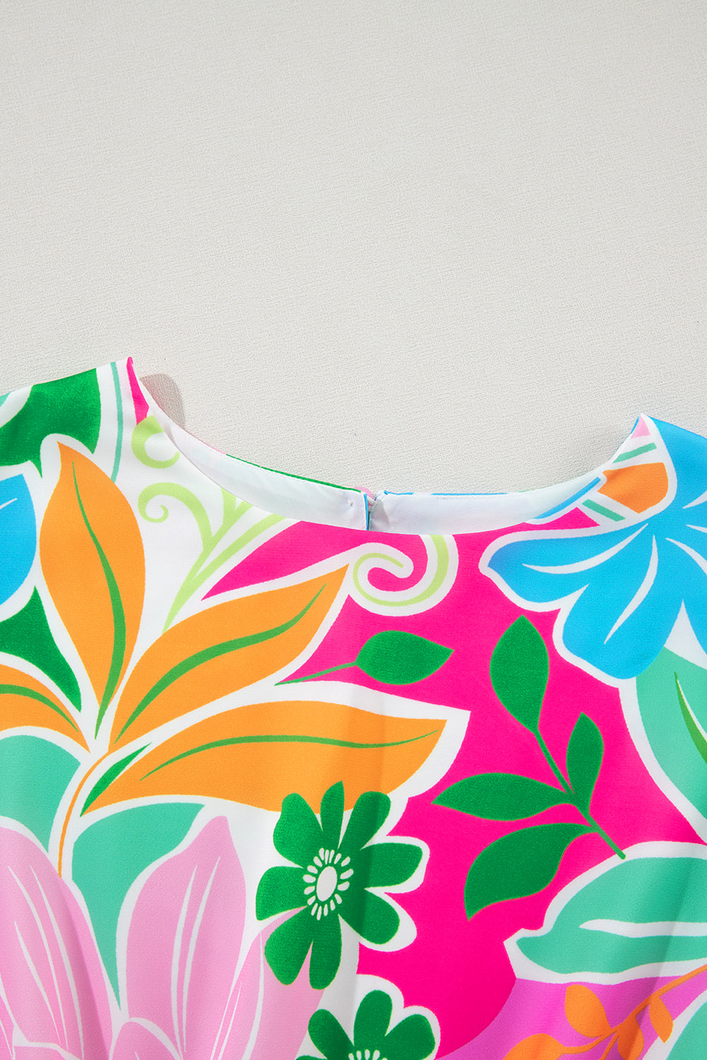 Colorful floral print dress close-up with vibrant leaves and flowers pattern