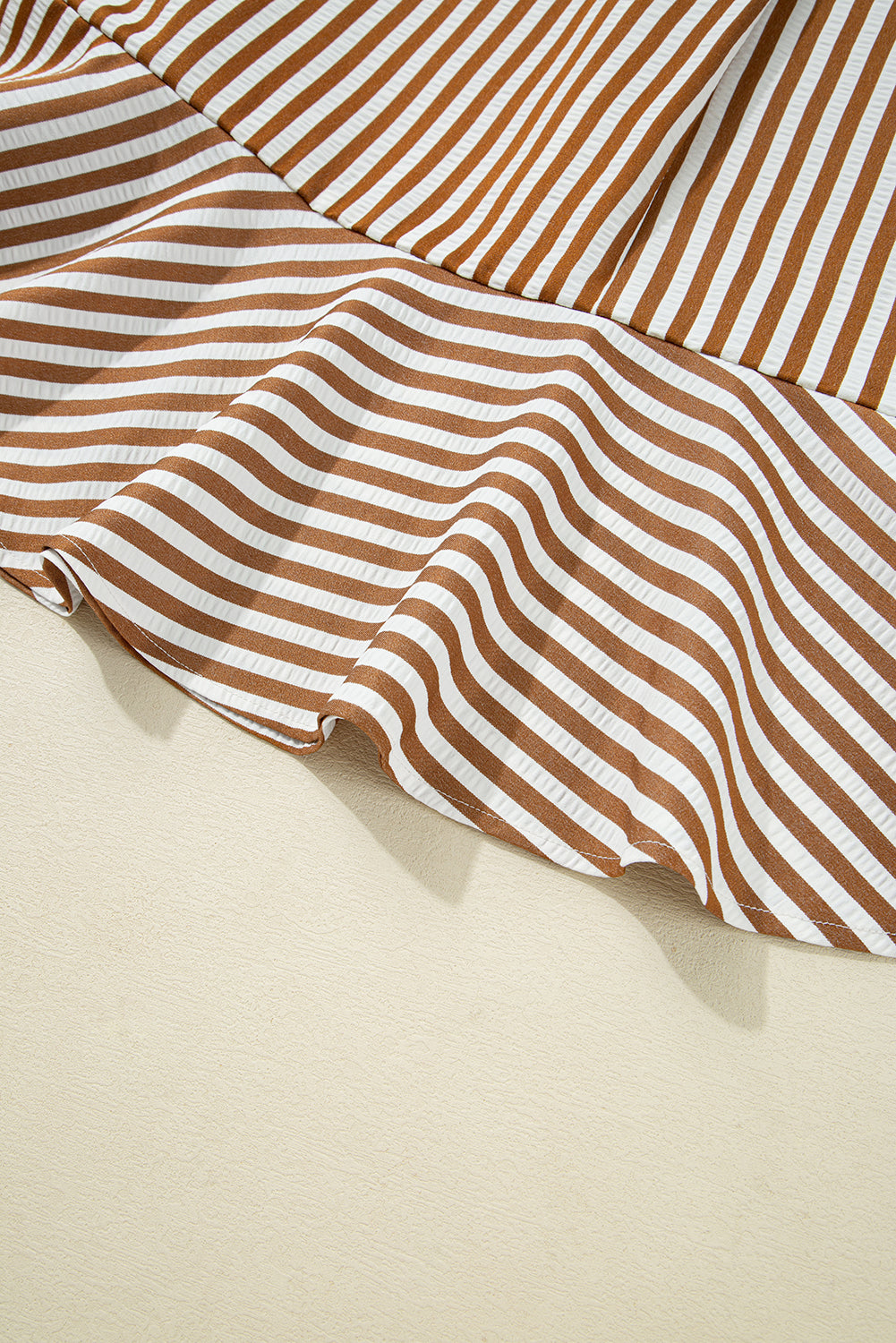 Brown and white striped ruffle hem fabric, close-up, lightweight textile detail