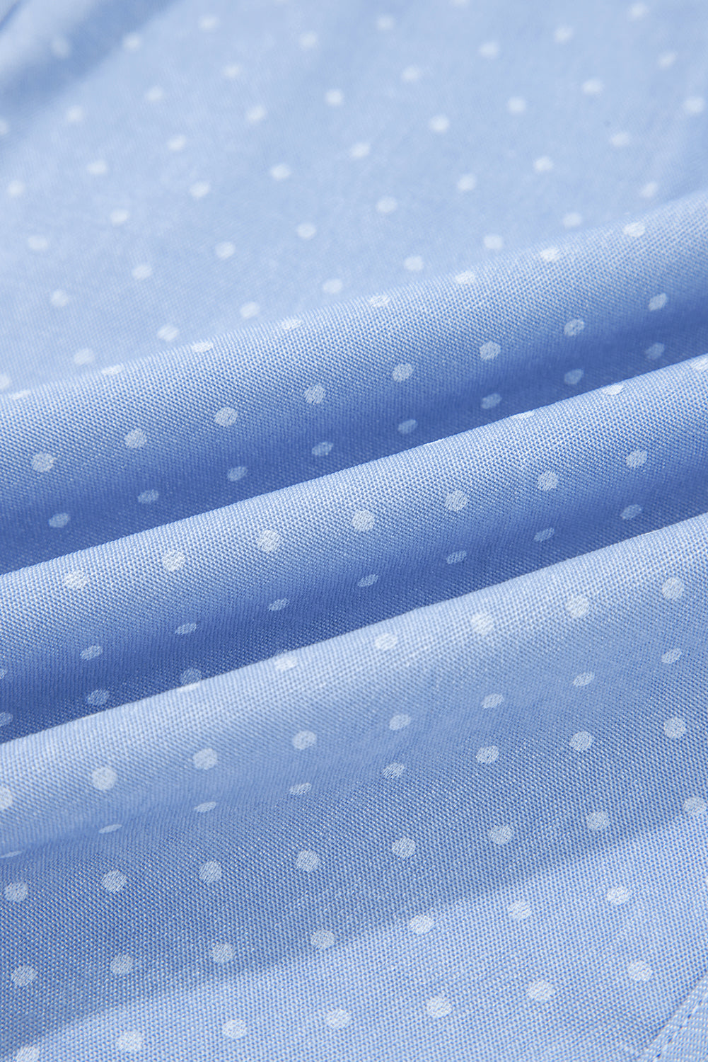 детайл на материя от лек деним в светлосин цвят с фини точки отблизо