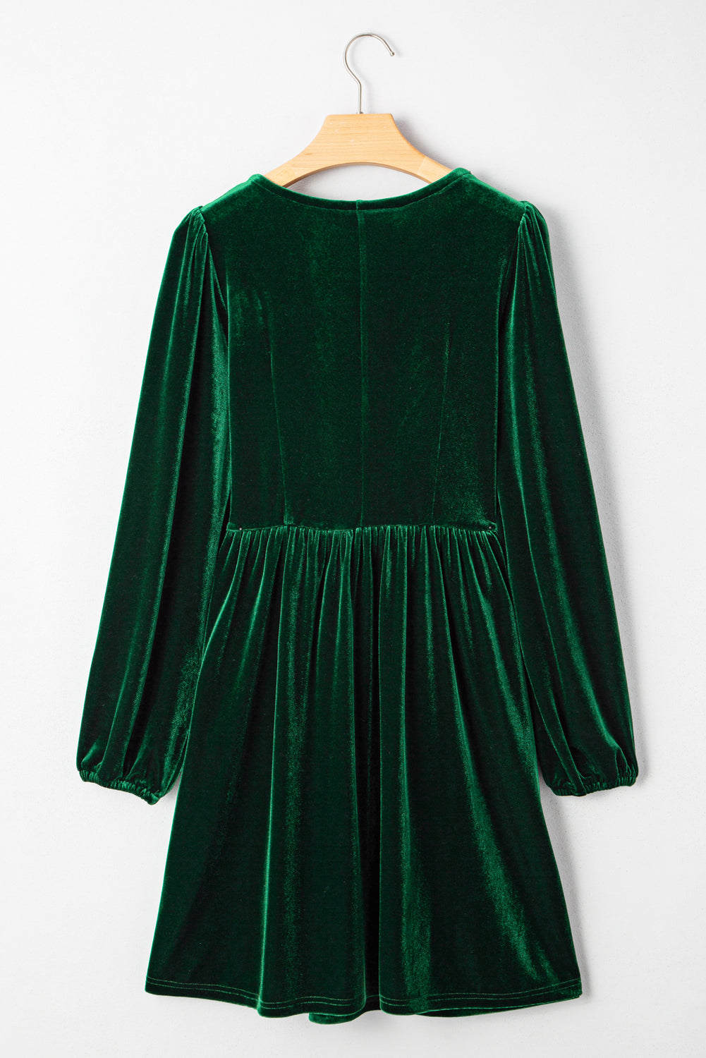 Green velvet long sleeve dress with gathered waist, displayed on hanger