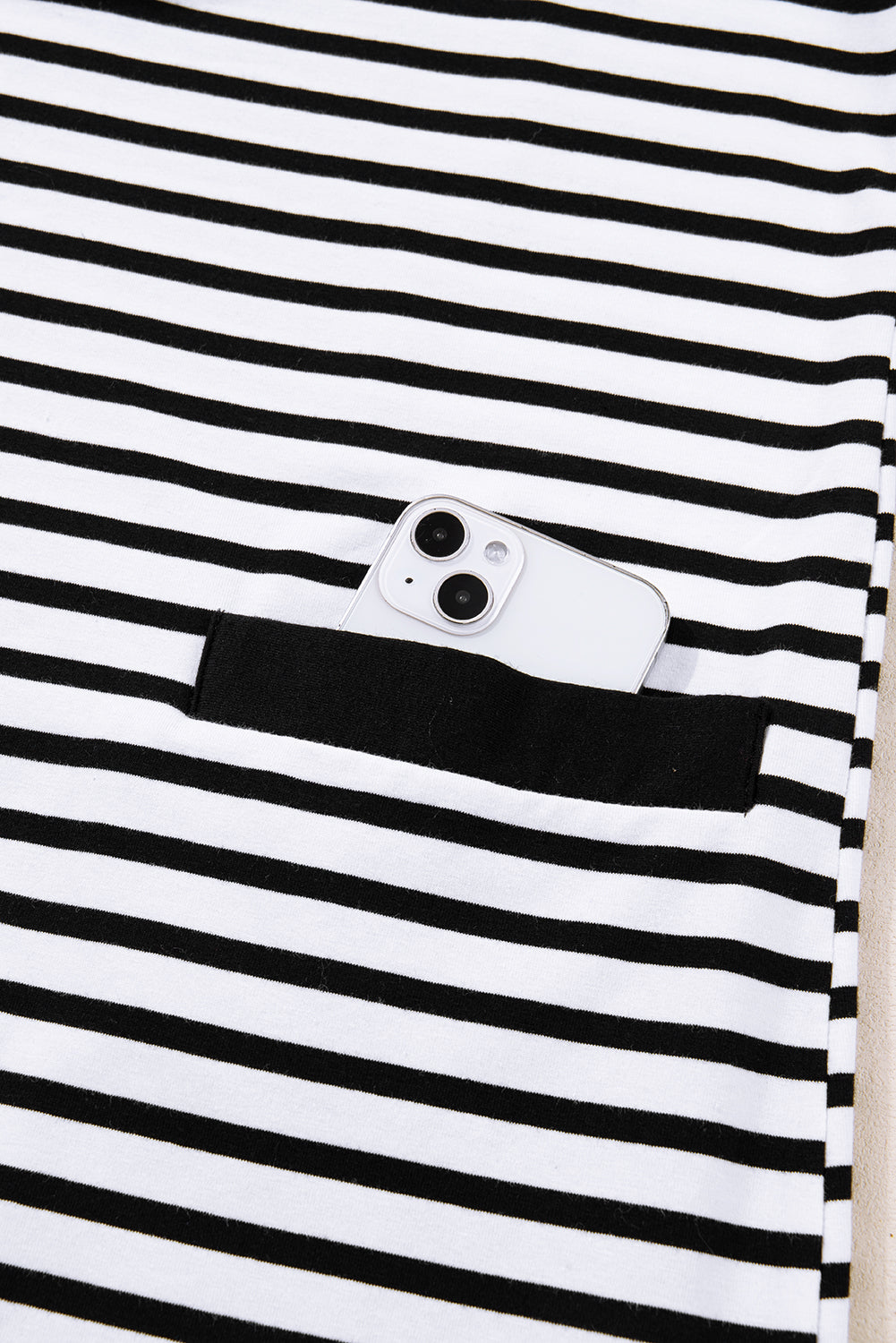 Black and white striped fabric with pocket holding a smartphone