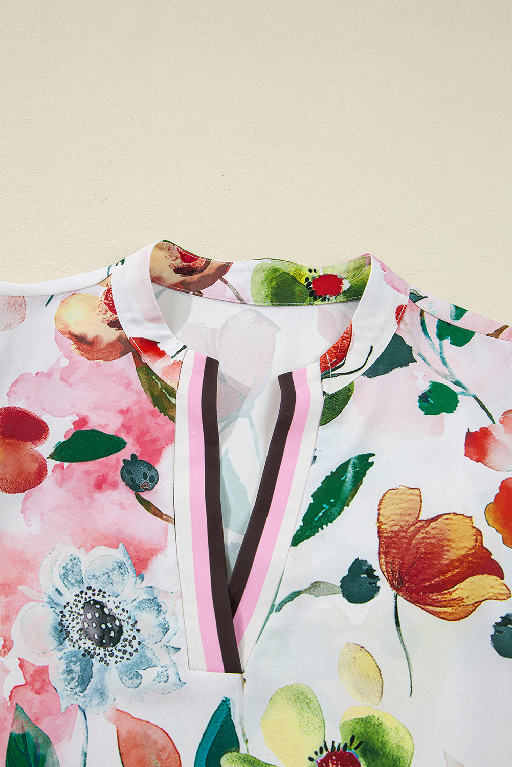 Close-up of a floral print blouse with a V-neck and colorful flower patterns