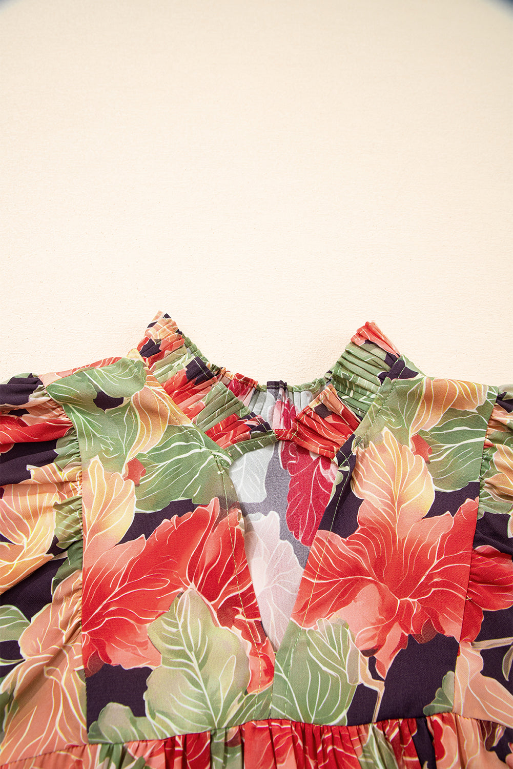 Floral print dress with colorful leaves and V-neck detail, close-up on neckline