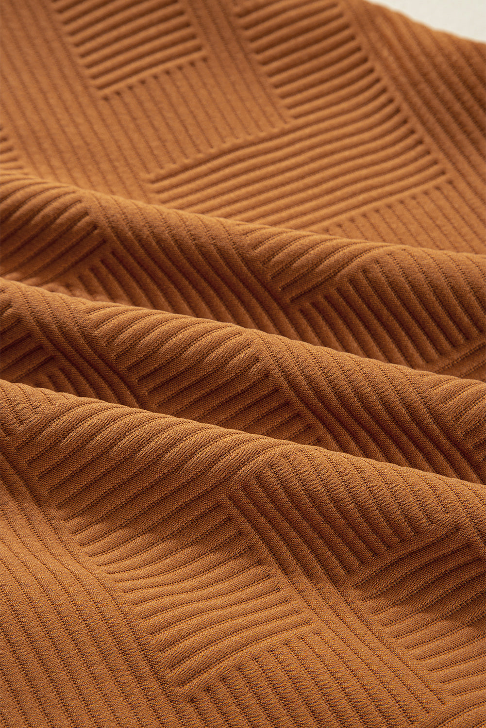 Close-up of textured brown ribbed fabric with geometric square pattern