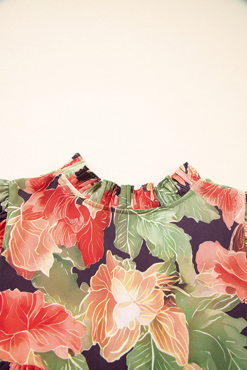 Close-up of floral print dress with ruched neckline and red, green, and yellow flowers