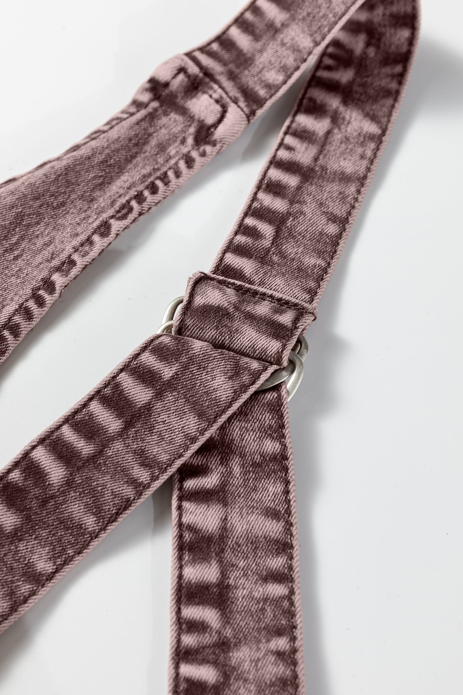 Close-up of mauve velvet adjustable strap with silver ring on white background